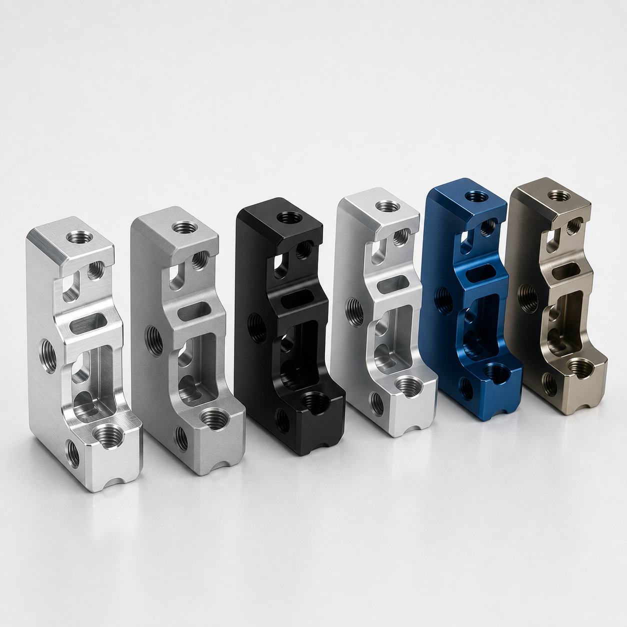 Identical CNC machined parts in raw, bead blasted, anodized, and plated finishes